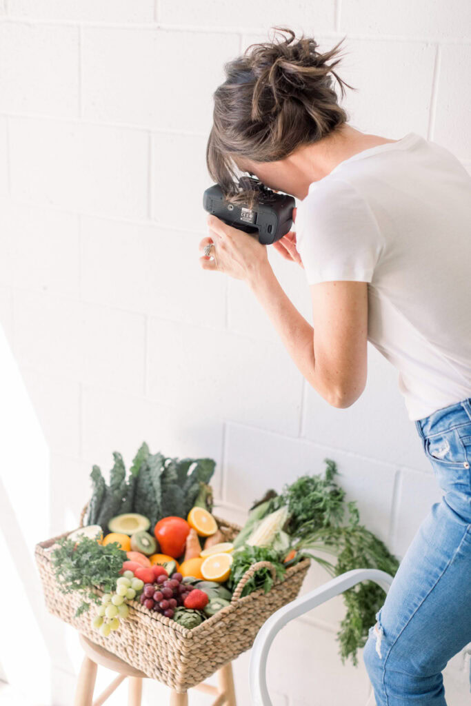 Gina Fontana taking a photo of a produce basket