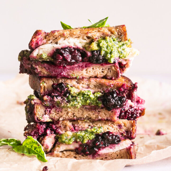 vertical image of vegan blackberry pesto grilled cheese sandwich stacked on top of one another