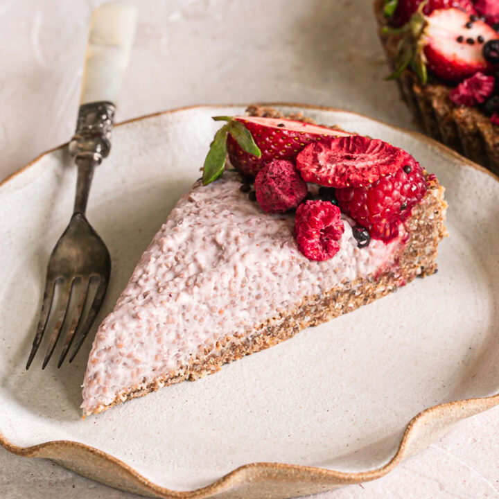 a slice of slices of breakfast chia yogurt granola tart decorated with fresh berries on a plate with a fork