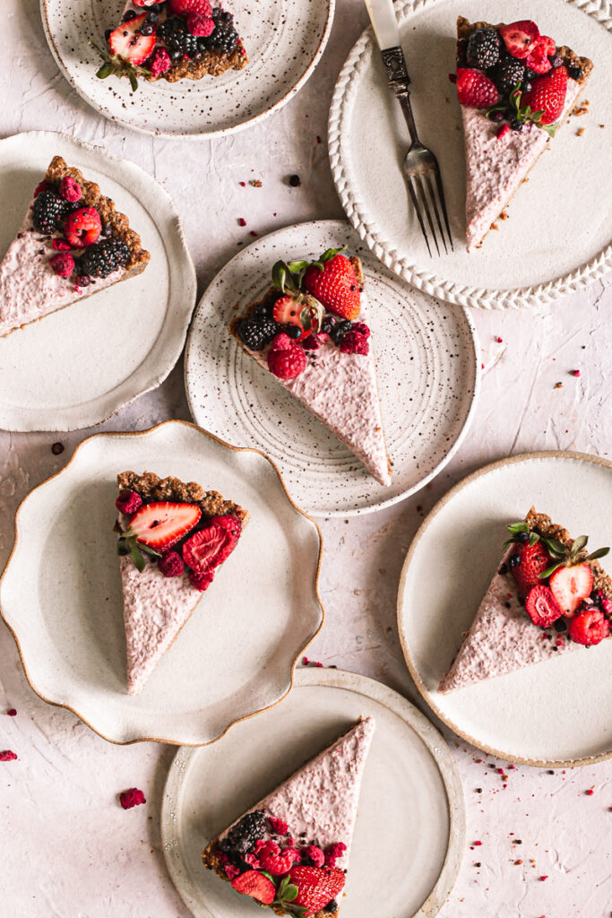 slices of breakfast chia yogurt granola tart decorated with fresh berries on plates