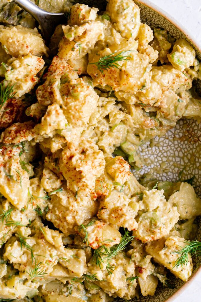 close up of smoked paprika dill potato salad with a spoonful scooped out