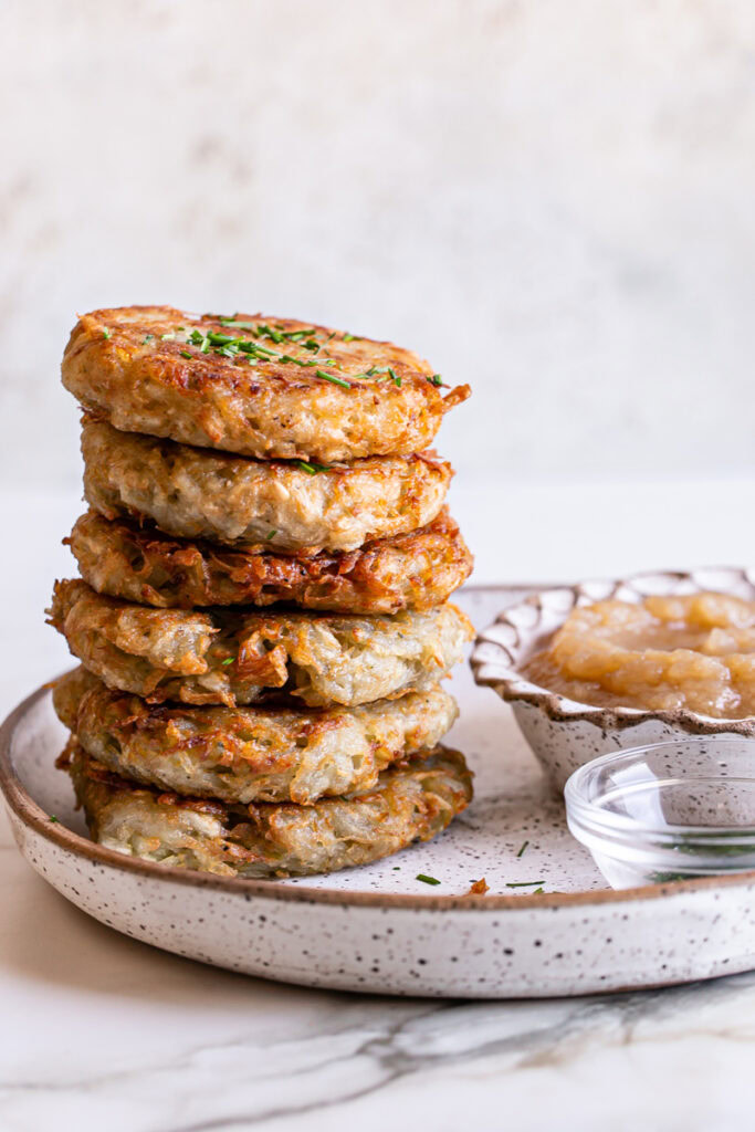 a stack of Gluten-Free Vegan Potato Pancakes served with a bowl of applesauce