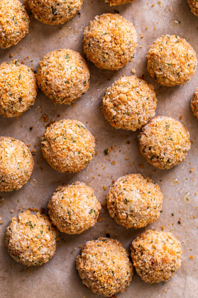 baked mashed potato croquettes on a baking sheet lined with parchment paper