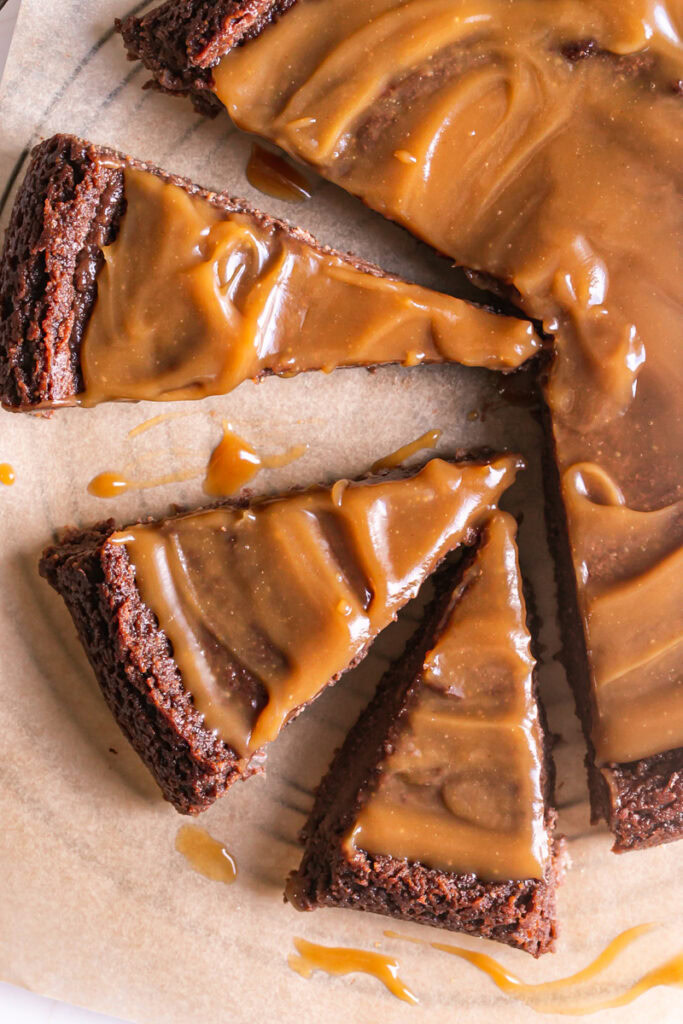 a closeup flatlay shot of chocolate caramel cheesecake with the slices spread apart