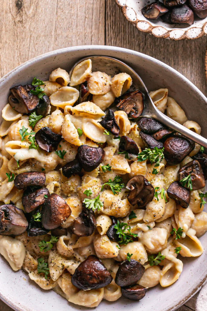 close up shot of a bowl of Creamy Alfredo Style Mushroom Pasta with a spoon in it