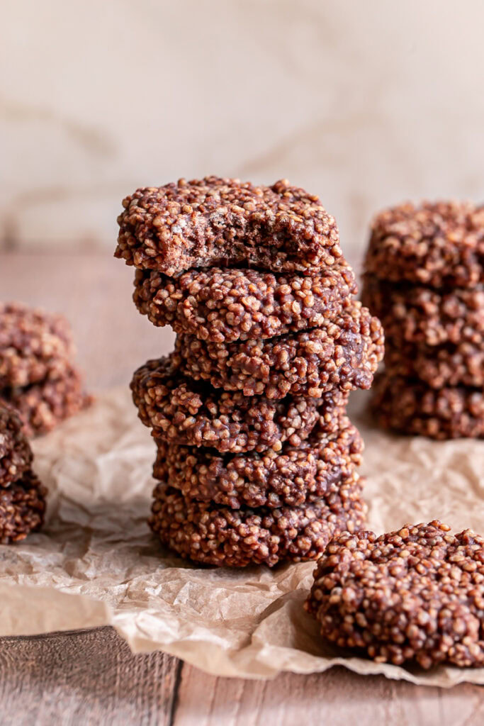 Crispy Quinoa Cacao Cookies  stacked on top of one another, the top one with a bite taken out of it