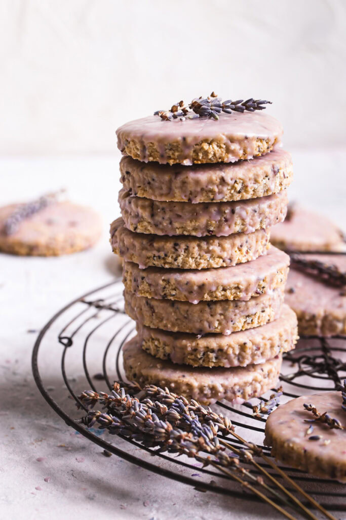 Lavender Vanilla Oatmeal Shortbread Cookies stacked on top of one another on a round wire cooling rack with a spring of lavender on the top cookie