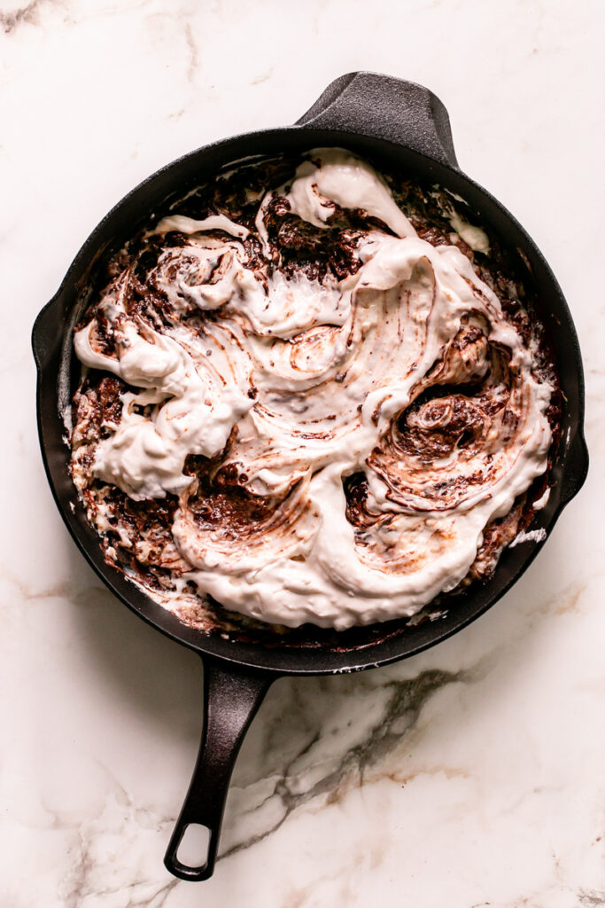 untested marshmallow fluff swirled with the melted chocolate in the cast iron skillet