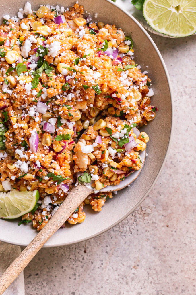 close up overhead shot of a bowl of Dairy-Free Mexican Street Corn Quinoa Salad with a spoon in it