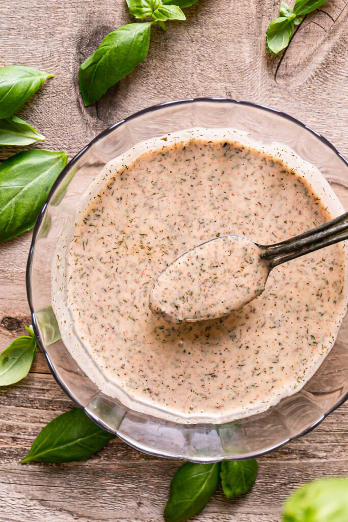 a bowl of vegan garlic herb dressing with a spoon in it