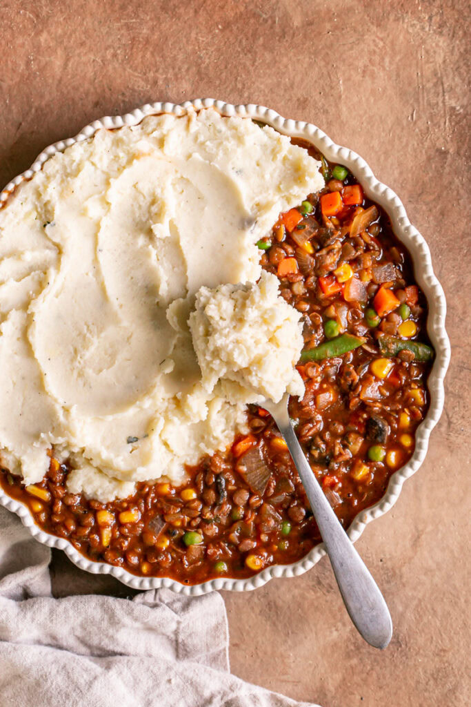 half of the shepherd's pie vegetable mixture covered with mashed potatoes