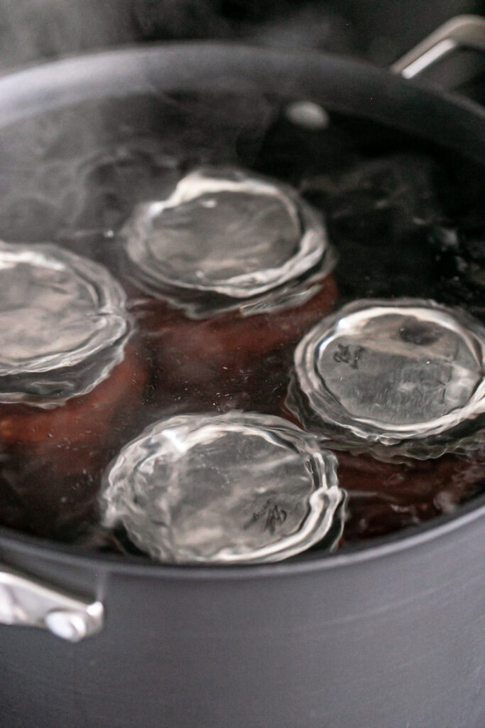 4 jars of salsa boiling in water