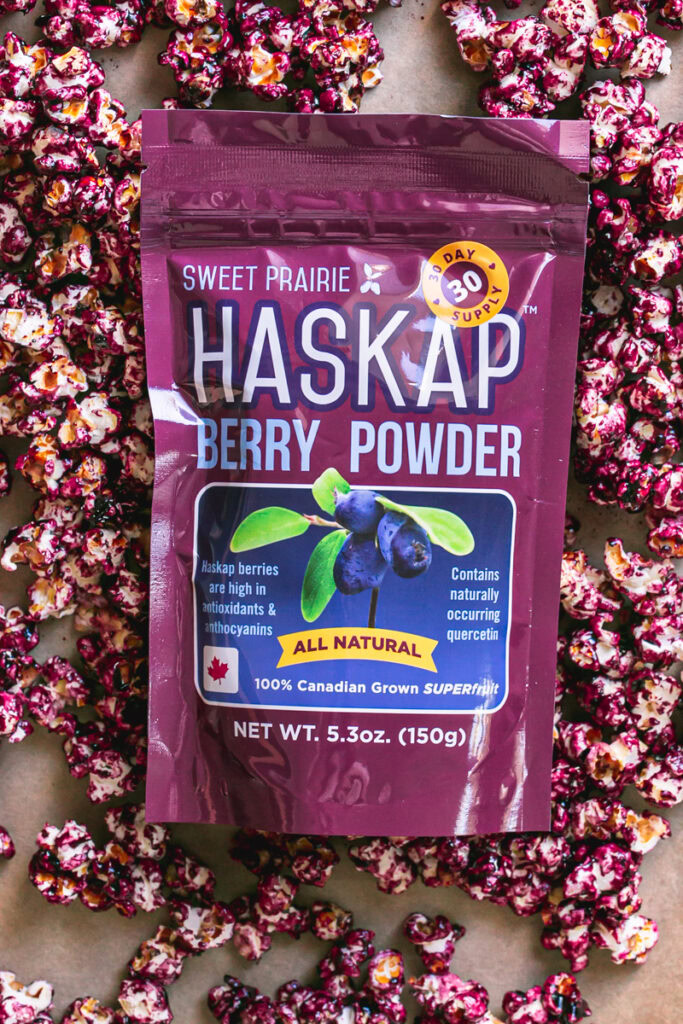 Candied Haskap Berry Popcorn with a bag of sweet prairie haskap powder on top