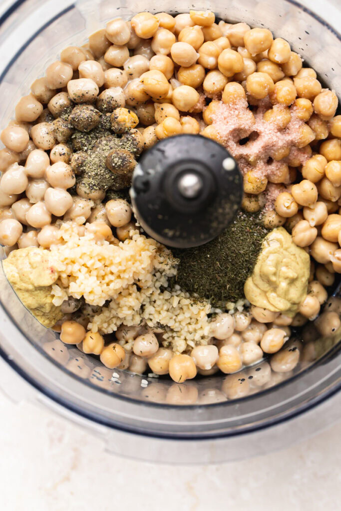 chickpeas, minced garlic, salt, pepper, dill, dijon mustard, lemon juice unblended in a food processor container