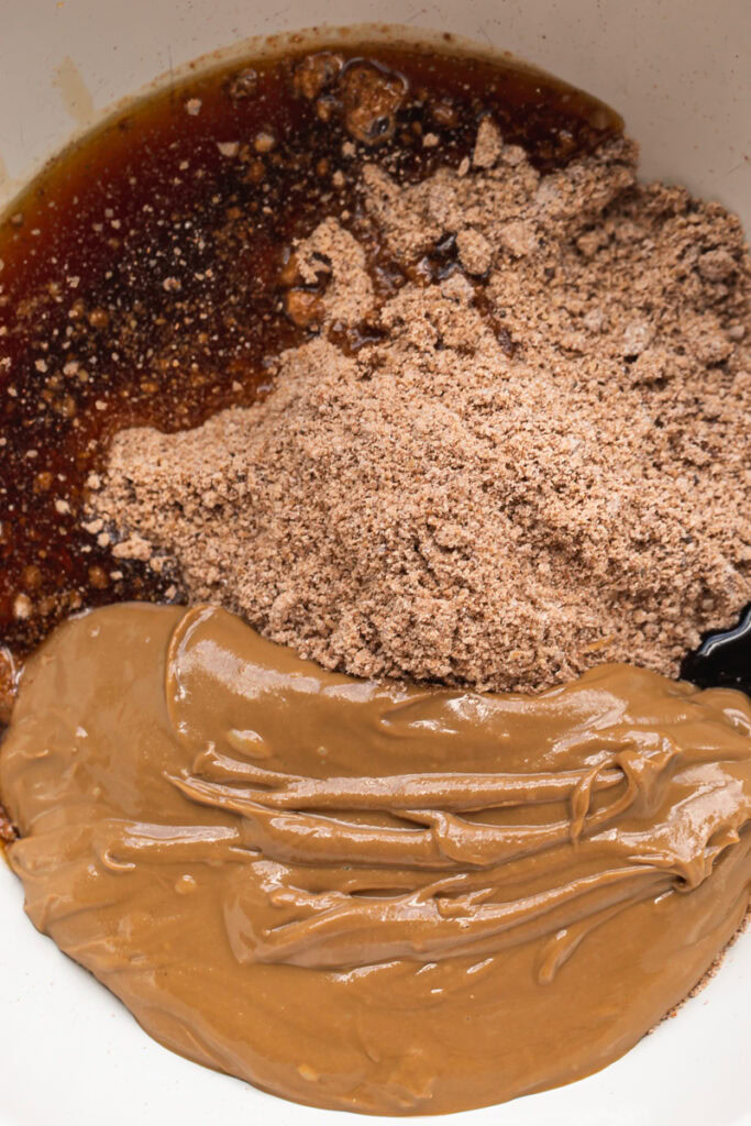 cookie crust crumbs in a bowl with sunflower seed butter and maple syrup